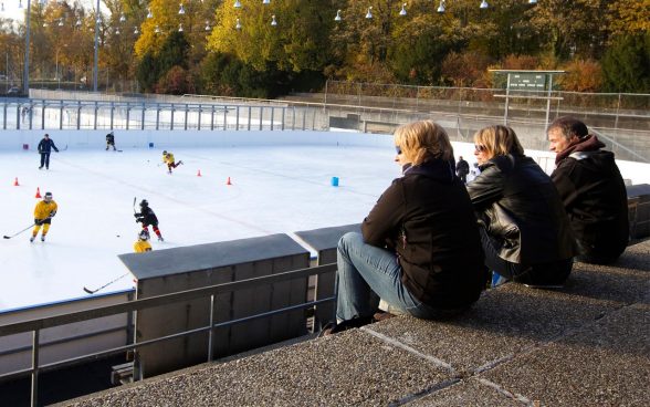 Eltern beobachten Kinder auf dem Eisfeld; Foto: BASPO / Ulrich Känzig
