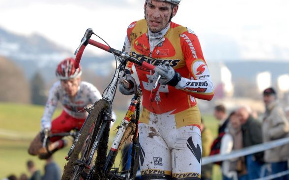 Ciclista di cross porta la sua bici nel fango: Foto: UFSPO